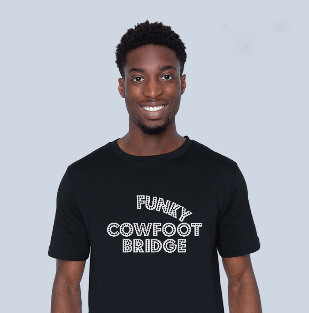 Man wearing a black teeshirt with white wording saying Rice Peas Tings