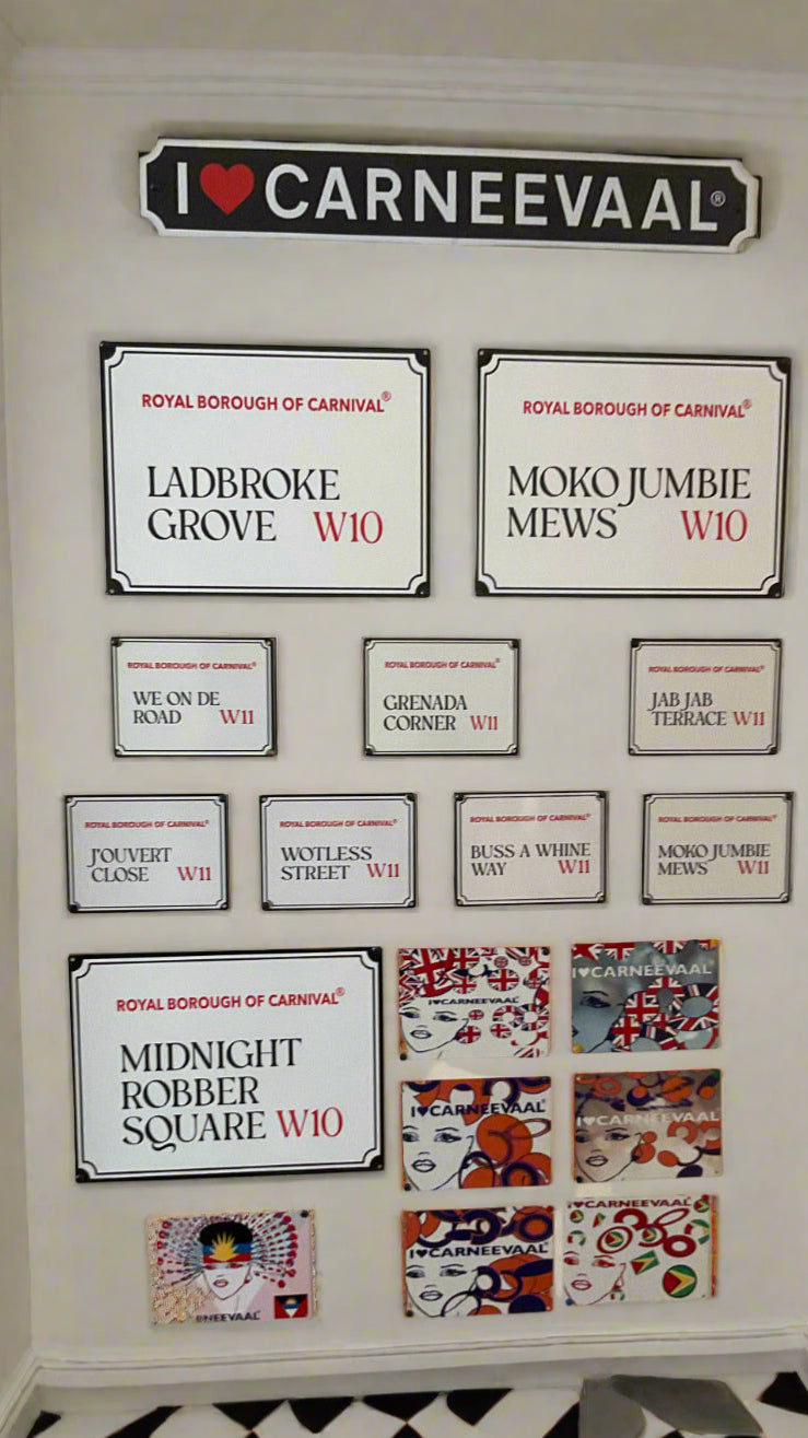 Gallery wall featuring all the mini decorative carnival signs in a hallway with black and white chequered flooring